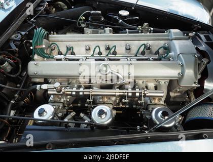Close up of an old in line six cylinder automobile engine with three carburettors. Head section with double overhead camshafts & spark plug leads. Stock Photo