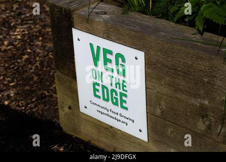 A notice on a raised, wooden garden planter. The planter belongs to a community gardening scheme called 'Veg on the Edge' in Saltaire, Yorkshire. Stock Photo