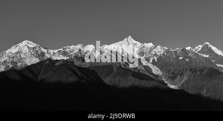 rolling snow mountains of meili range in black and white Stock Photo