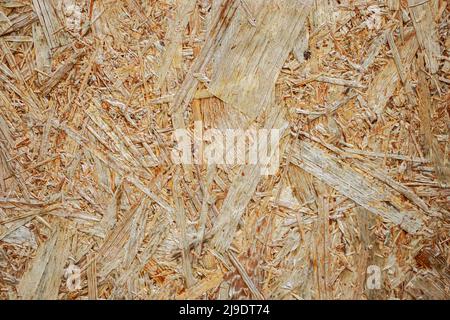 Pressed shavings close-up. Wooden texture OSB Board. Building material for renovation. Stock Photo