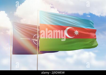 Sunny blue sky and flags of azerbaijan and nato Stock Photo