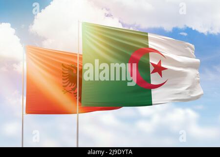 Sunny blue sky and flags of algeria and albania Stock Photo