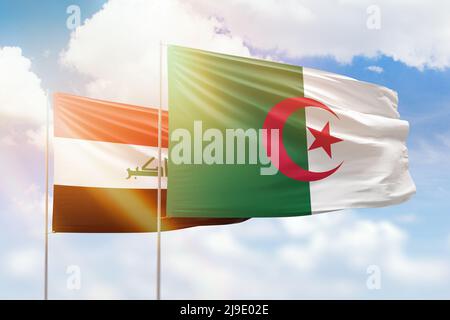 Sunny blue sky and flags of algeria and iraq Stock Photo
