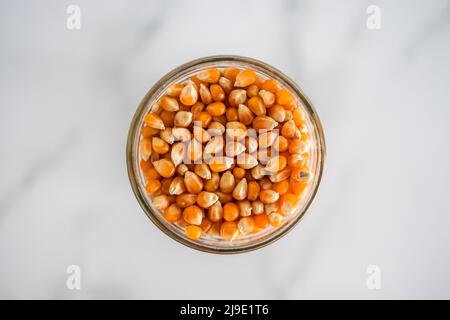 corn kernels for making popcorn in glass jar, concept of simple natural healthy ingredients Stock Photo