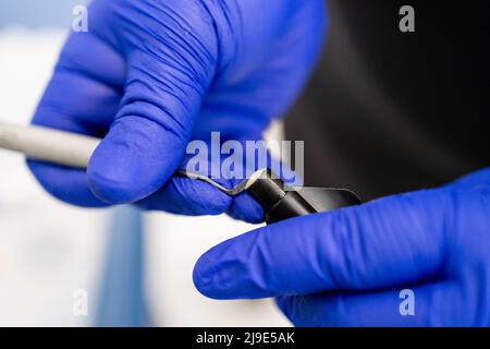 Dentist putting dental plugger into composite resins vial. Composite filling material used in dentistry Stock Photo