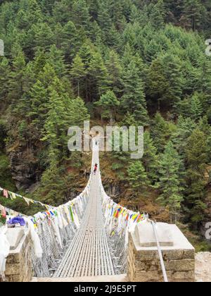 Prayer flags adorn the Hillary Bridge near the confluence of the Bhote Koshi and Dudh Koshi below Namche Bazaar. Stock Photo