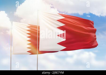 Sunny blue sky and flags of bahrain and qatar Stock Photo