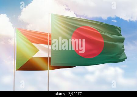 Bangladesh and Sudan flags waving together on blue cloudy sky, two ...