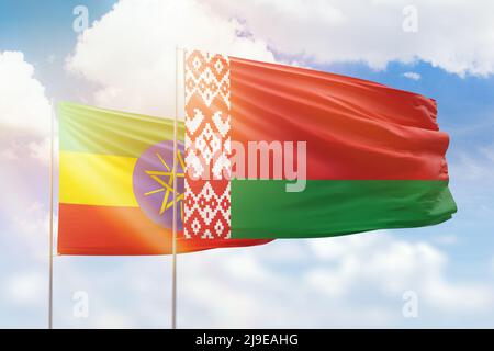 Ethiopia and Belarus flags waving together on blue cloudy sky, two ...