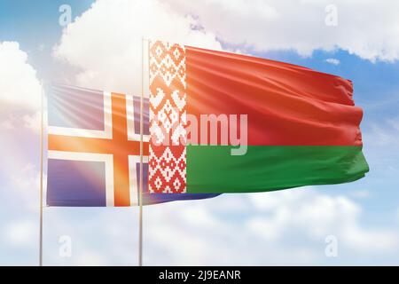 Iceland and Belarus flags waving together in the wind on blue cloudy ...