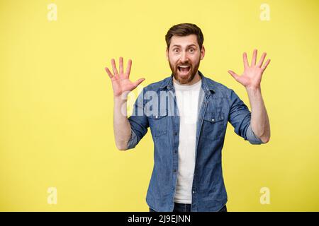 Scared man with raised his hands up and shouting sees something in front Stock Photo