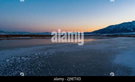 Beautiful sunset over frozen Little Bear River, Logan, Utah, USA Stock Photo