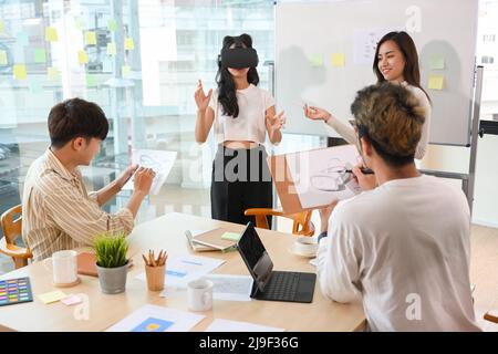 A tech startup company, a group of tech developers and graphic designers testing a new version of VR game via VR headset. Stock Photo
