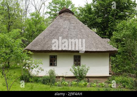 Ukrainian village. House with thatched roof. Wild village in Ukraine. Traditional house of ukraine. Clay house. Stock Photo