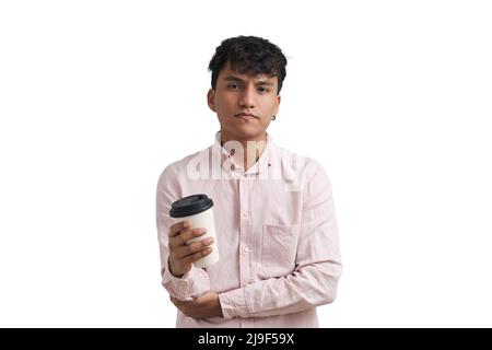 Young peruvian man wearing a pink shirt stand with a coffee cup, isolated. Stock Photo