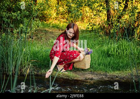 Connecting with nature benefits mental health. Nature Therapy Ecotherapy Helps Mental Health. Nature Impact Wellbeing. Woman in red dress enjoying Stock Photo