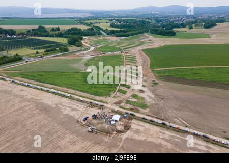 Mittelherwigsdorf, Germany. 23rd May, 2022. Construction vehicles stand on the building site for the new construction of the federal highway 178n between Niederoderwitz and Zittau (aerial photograph taken with a drone). The approximately six-kilometer-long section represents an important gap closure of the connecting axis between highway 4 and the federal border in the border triangle of Germany, Poland and the Czech Republic. Credit: Sebastian Kahnert/dpa/Alamy Live News Stock Photo