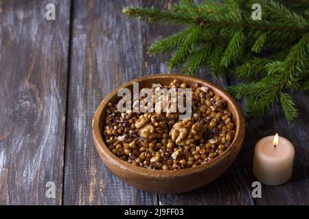 Sochivo, kutya - traditional Slavic holiday ritual dish (Russian, Ukrainian, Belarusian) of whole wheat, poppy, walnuts and honey in wooden bowl on wo Stock Photo