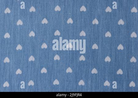 Background of white drawings of hearts on blue fabric background Stock Photo