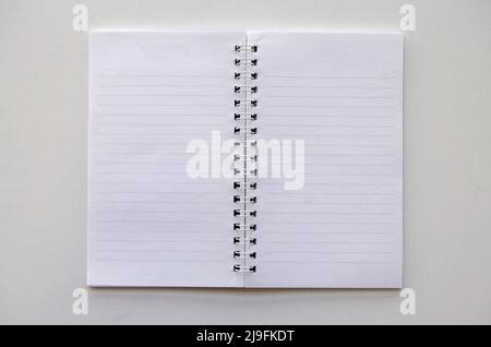 Top view isolated opened lined paper spriral small notepad on white background, office - education concept Stock Photo