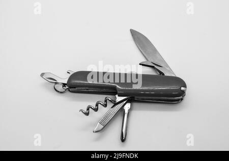 Isolated black and white switzerland knife, multi tool opened swiss army knife with wine opener in white background Stock Photo