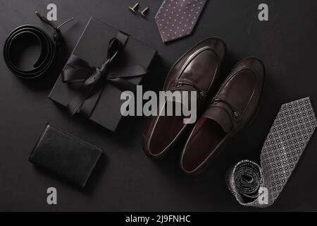 Set of classic mens accessories - shoes, belt , wallet and gift on black background. Top view. Flat lay. Concept mens design and Fashion. Father's Day Stock Photo
