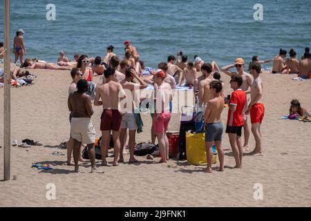 Barcelona, Spain. 22nd May, 2022. A group of tourists is seen exposed to the sun on the beach of Barceloneta. Barcelona reached a historic temperature record for the month of May. The thermometers touched 30 degrees Celsius, which encouraged residents and tourists to protect themselves from the sun or go to the beach areas to cool off. (Photo by Paco Freire/SOPA Images/Sipa USA) Credit: Sipa USA/Alamy Live News Stock Photo