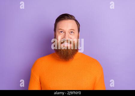 Photo of charming positive ginger man look up generate creative ideas isolated on violet color background Stock Photo