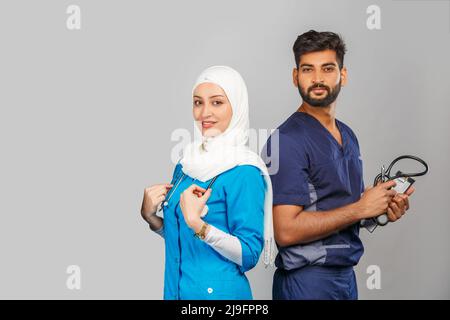 professional muslim doctor woman and indian assistant discuss tasks. portrait of beautiful medical workers with stethoscopes. Medical help, insurance Stock Photo