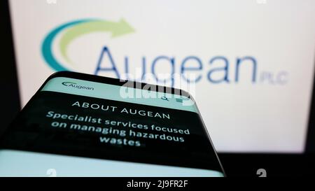Mobile phone with website of British waste management company Augean plc on screen in front of business logo. Focus on top-left of phone display. Stock Photo
