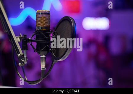 Horizontal no people selective focus shot of microphone with disc pop filter in modern recording studio Stock Photo