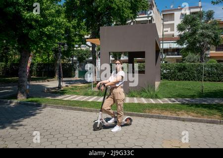 Young woman sitting on her stant-up electric scooter Stock Photo