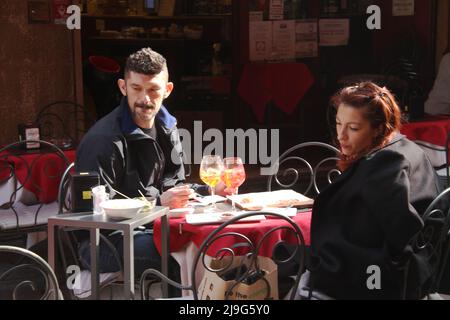 Couple sitting at an outside restaurant table in an Italian city Stock Photo