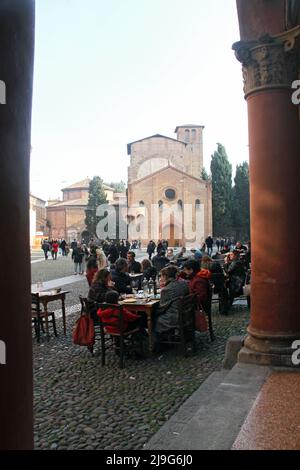 Bologna, Italy. Outdoor seating area of a local restaurant in Piazza Santo Stefano, with Basilica Santo Stefano in the back. Stock Photo
