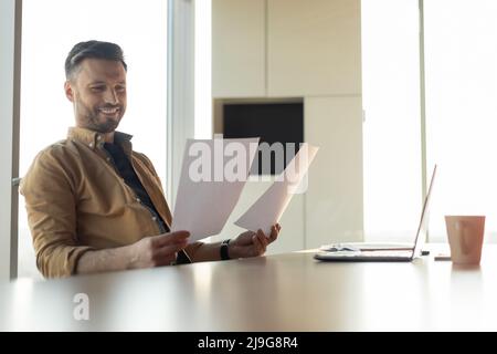Joyful Businessman Reading Papers Having Success At Work In Office Stock Photo
