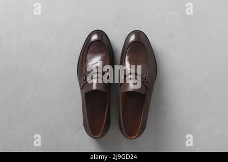 Classic male brown leather shoes isolated on gray concrete background. Top view. Flat lay. Stock Photo