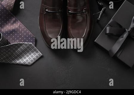 Set of classic mens accessories - shoes, belt and gift on black background. Father's Day. Stock Photo