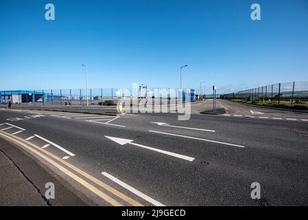 Looking across to the harbour railway station access road which lies between fenced off & disused former ferry port land and facilities. Stock Photo