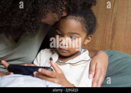 Daughter and mother using smart phone Stock Photo