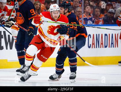 Calgary Flames forward Andrew Mangiapane, left, is checked by