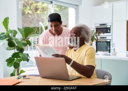 Couple using laptop in kitchen Stock Photo