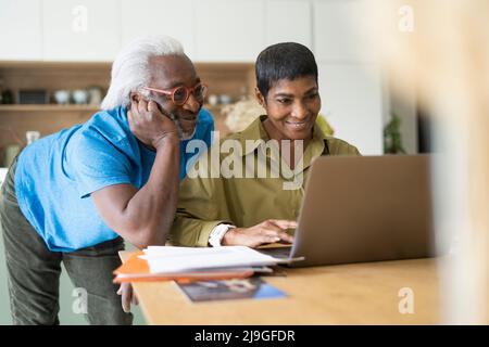 Couple using laptop in kitchen Stock Photo