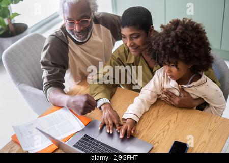Grandparents with granddaughter using laptop Stock Photo