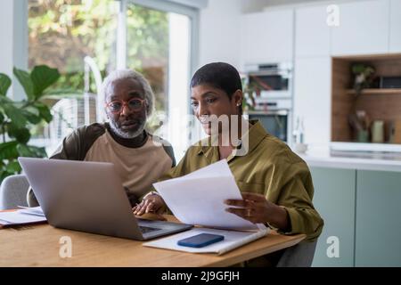 Couple checking documents in kitchen Stock Photo
