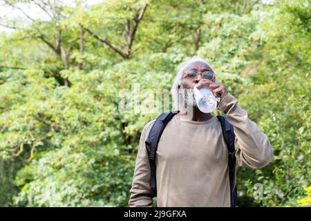 Senior man drinking water with his eyes closed Stock Photo