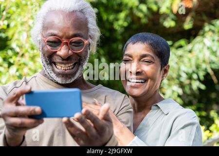 Smiling couple taking selfie with smart phone Stock Photo