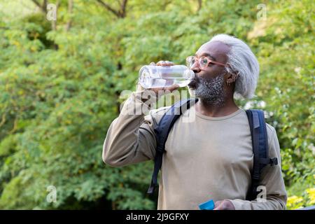 Senior man drinking water and looking away Stock Photo