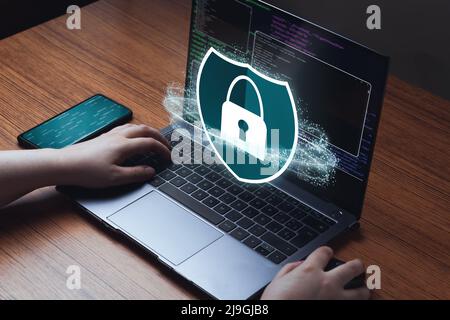 Woman use laptop with protection interface. Internet of things. Cybersecurity concept. Icon shield with a lock symbol and encryption screen. Stock Photo