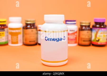 Dietary supplements omega-3 in a white jar and other jars on an orange background Stock Photo