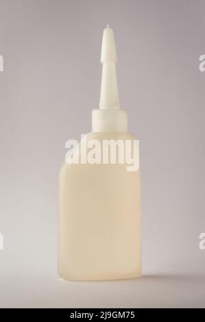 all purpose machine oil bottle, small plastic multipurpose lubricant container isolated on a neutral grey background, mockup template Stock Photo